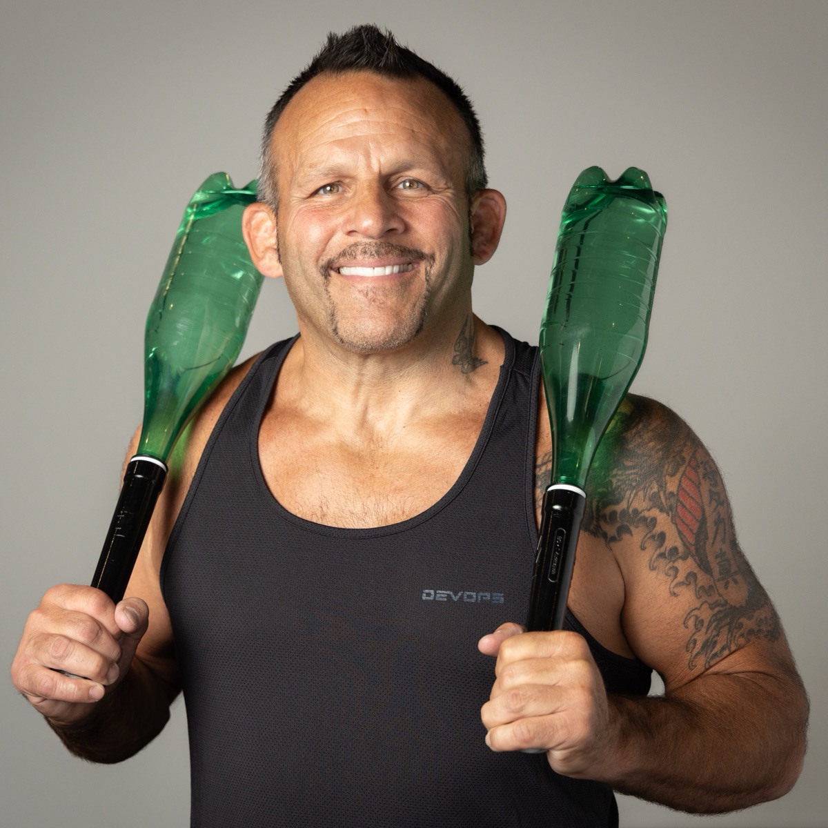 Coach Kenny Johnson holding two water bottles fitted with Bolt Club Handles